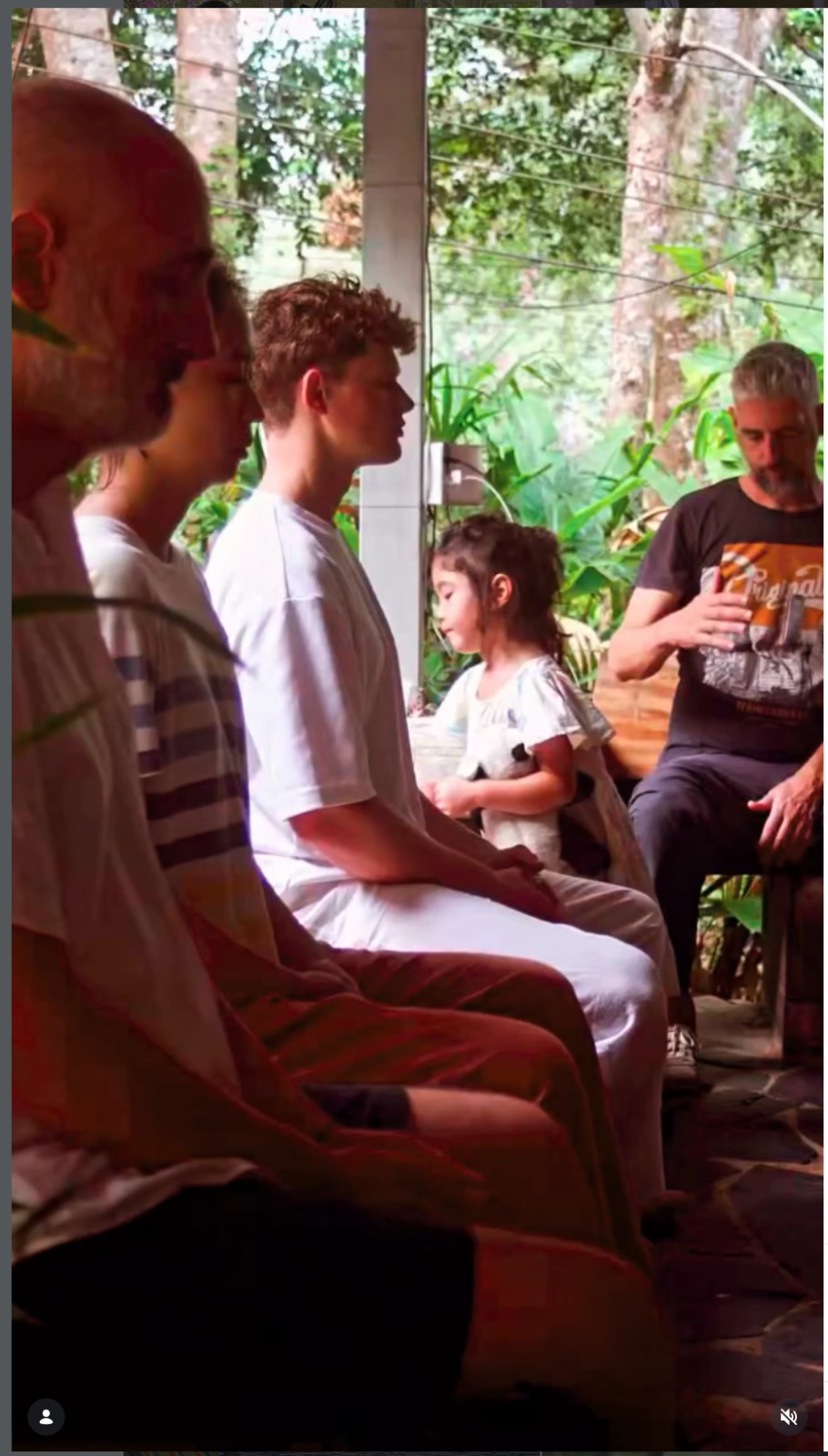 A row of people, including Bruno, sitting in quiet meditation before practice
